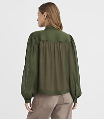 A woman in a green blouse stands against a plain white background. carousel Product Image 4