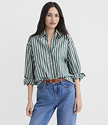 A woman in a green and white striped shirt and blue jeans stands against a plain white background. carousel Product Image 2