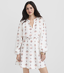 A woman in a white patterned dress stands against a plain white background. carousel Product Image 2