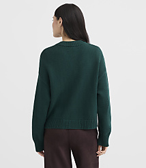 A woman in a dark green sweater and brown pants stands against a plain white background. carousel Product Image 3