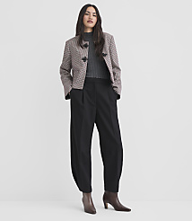 A woman in a patterned jacket and black pants stands against a plain white background. carousel Product Image 1