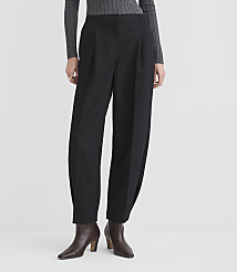 A person stands in black pleated trousers and brown ankle boots against a plain white background. carousel Product Image 2