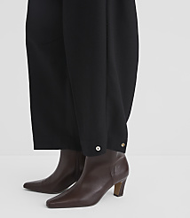 Black wide-leg trousers with silver button details are worn over brown leather ankle boots against a plain white background. carousel Product Image 4