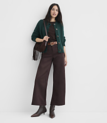 A woman in a green cardigan and brown wide-leg pants stands against a plain white background, accessorized with a brown crossbody bag and heeled boots. carousel Product Image 2