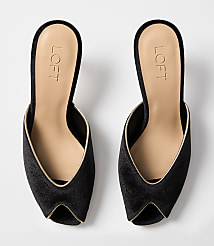 A pair of black velvet mules with gold trim are displayed against a plain white background. carousel Product Image 3