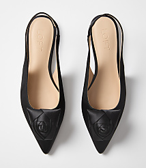 A pair of black satin slingback heels with a rose detail on the toe sit on a plain white background. carousel Product Image 3