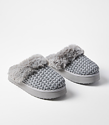 A pair of gray knitted slippers with faux fur trim rests on a white background. carousel Product Image 1
