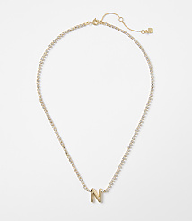 A gold letter "N" charm hangs from a delicate, diamond-encrusted chain against a plain white background. carousel Product Image 1