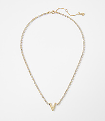 A gold necklace with a "V" pendant rests on a plain white background. carousel Product Image 1