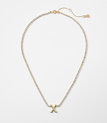 A gold letter "X" pendant on a diamond-encrusted chain rests against a plain white background. carousel Product Image 1