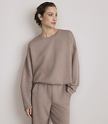 A woman in a taupe sweatshirt and matching pants stands against a plain, light gray background. carousel Product Image 2
