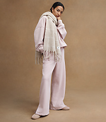 A woman in a pink loungewear set and a beige scarf stands against a plain brown background. carousel Product Image 4