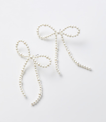 Two delicate pearl bow earrings with dangling strands are arranged on a plain white background. carousel Product Image 1