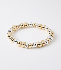 A bracelet of mixed gold and silver beads rests on a plain white background. carousel Product Image 1