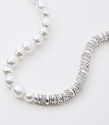 A pearl necklace with a section of sparkling silver beads curves across a white background. carousel Product Image 2