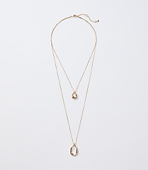 A delicate gold layered necklace with two abstract pendant shapes hangs against a plain white background. carousel Product Image 1