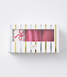 A white box with gold and silver stripes contains three pairs of pink socks, one with a bow, one striped, and one glittery, against a plain white background. carousel Product Image 1