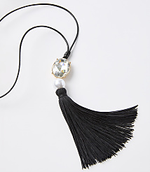 A black tassel necklace with a clear gem and pearl hangs against a plain white background. carousel Product Image 2