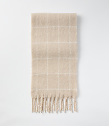 A fuzzy, beige plaid scarf with fringe lies on a plain white background. carousel Product Image 2