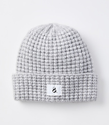 A light gray knitted beanie with a waffle knit pattern and a white tag with a black ampersand sits on a plain white background. carousel Product Image 1