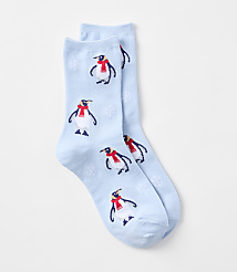 A pair of light blue socks with a pattern of penguins wearing red scarves and snowflakes are laid out against a plain white background. carousel Product Image 1