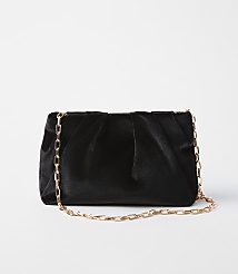 A black velvet clutch with a gold chain strap rests on a plain white background. carousel Product Image 1