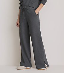A person wearing dark gray wide-leg sweatpants with a drawstring waist and side slits stands in front of a plain background. carousel Product Image 2