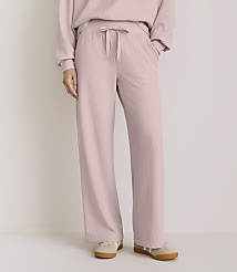 A person wearing pink ribbed lounge pants and sneakers stands against a plain, light-colored background. carousel Product Image 2