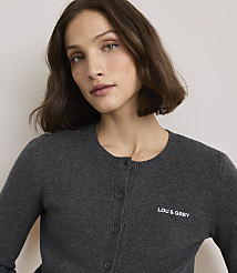 A woman in a dark grey cardigan with "LOU & GREY" embroidered on the chest is shown against a plain, light grey background. carousel Product Image 1