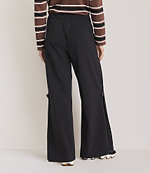 A person wearing black wide-leg pants with side slits and a striped long-sleeved shirt stands against a plain white background. carousel Product Image 3