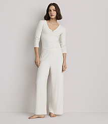A woman in a cream-colored pajama set stands against a plain, light gray background. carousel Product Image 1