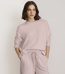 A woman in a pink sweater and matching pants stands against a plain, light background. carousel Product Image 1