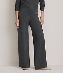 A person wearing dark gray wide-leg knit pants with cargo pockets stands on a light-colored floor, with a plain background. carousel Product Image 2