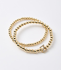A gold beaded bracelet with a diamond-encrusted clasp is coiled on a plain white background. carousel Product Image 1
