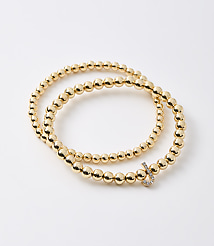 A gold beaded bracelet with a diamond-encrusted clasp rests on a plain white background. carousel Product Image 1
