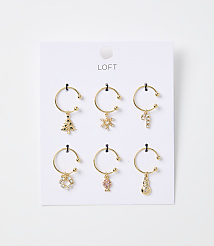 Six gold-toned hoop earrings with festive Christmas charms hang from a white card with the "LOFT" logo against a plain white background. carousel Product Image 1