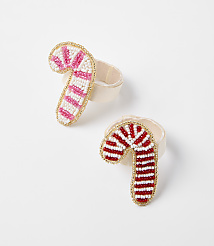 Two beaded candy cane napkin rings, one pink and white and the other red and white, rest on a plain white surface. carousel Product Image 1