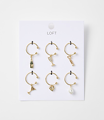 Six gold wine charms, each with a different miniature charm, hang from a white card with the "LOFT" logo at the top. carousel Product Image 1