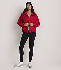 A woman in a red jacket and black leggings sits against a plain gray background. carousel Product Image 2