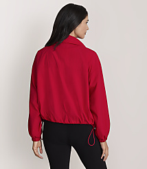 A woman in a red jacket and black leggings stands against a plain gray background. carousel Product Image 3