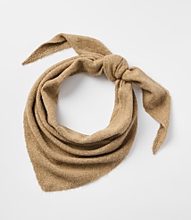 A tan, triangular scarf is tied in a knot in the foreground against a plain white background. carousel Product Image 1