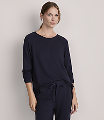 A woman in a navy blue long-sleeved shirt and matching pants stands against a plain gray background. carousel Product Image 1