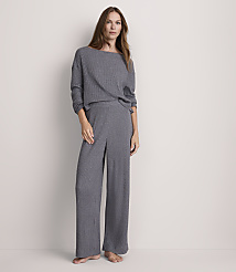 A woman stands in a grey ribbed loungewear set against a plain, light grey background. carousel Product Image 1