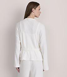 A woman in a white waffle-knit robe and pants stands against a plain, light gray background. carousel Product Image 3