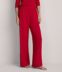 A person stands in red pajama pants and a matching top against a plain, light gray background. carousel Product Image 2