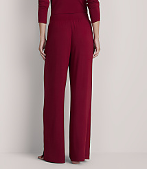 A person stands in loose-fitting, dark red pajama pants in the foreground, against a plain, light-colored background. carousel Product Image 3