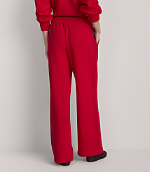 A person wearing red sweatpants and a matching top stands against a plain, light-colored background. carousel Product Image 3