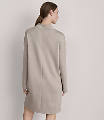 A woman in a beige sweater dress stands against a plain, light gray background. carousel Product Image 3