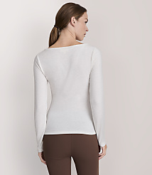 A woman in a white long-sleeved shirt and brown leggings stands against a plain white background. carousel Product Image 3