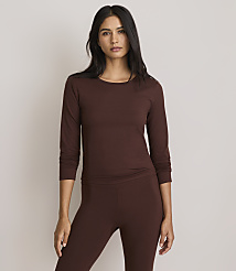 A woman in a brown long-sleeved shirt and leggings stands against a plain, light gray background. carousel Product Image 2